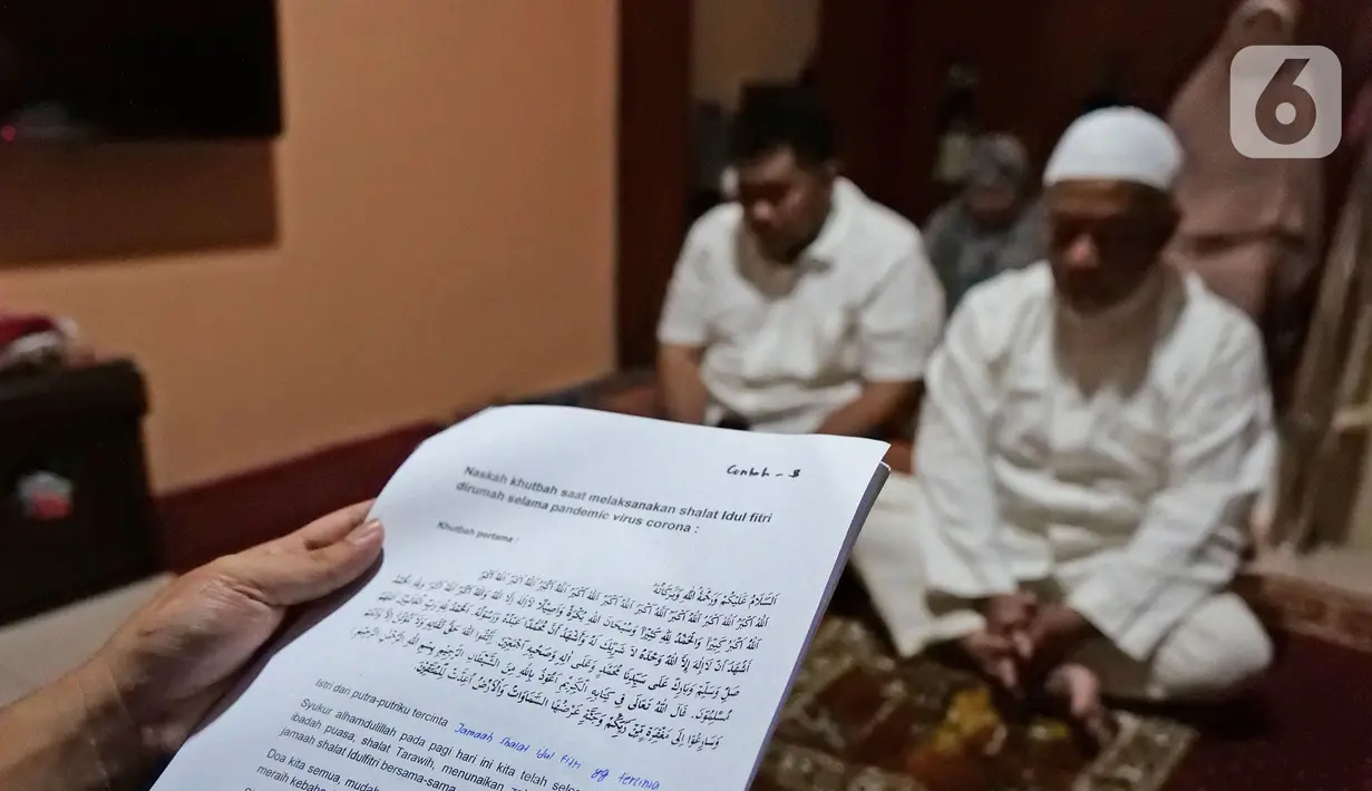 Warga mendengarkan khotbah saat melaksanakan salat Idul Fitri di kediamannya kawasan Mekarsari, Depok, Jawa Barat, Minggu (24/5/2020). Warga menjalankan salat Idul Fitri di rumah saat pandemi COVID-19. (Liputan6.com/Herman Zakharia)