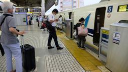 Penumpang naik kereta peluru Shinkansen di stasiun kereta Shin-Yokohama di Yokohama, Prefektur Kanagawa (22/7/2020). Kampanye "Go To Travel" menawarkan subsidi dan diskon untuk pelancong dalam upaya menghidupkan industri pariwisata domestik yang dilanda pandemi COVID-19. (AFP Photo/Kazuhiro Nogi)