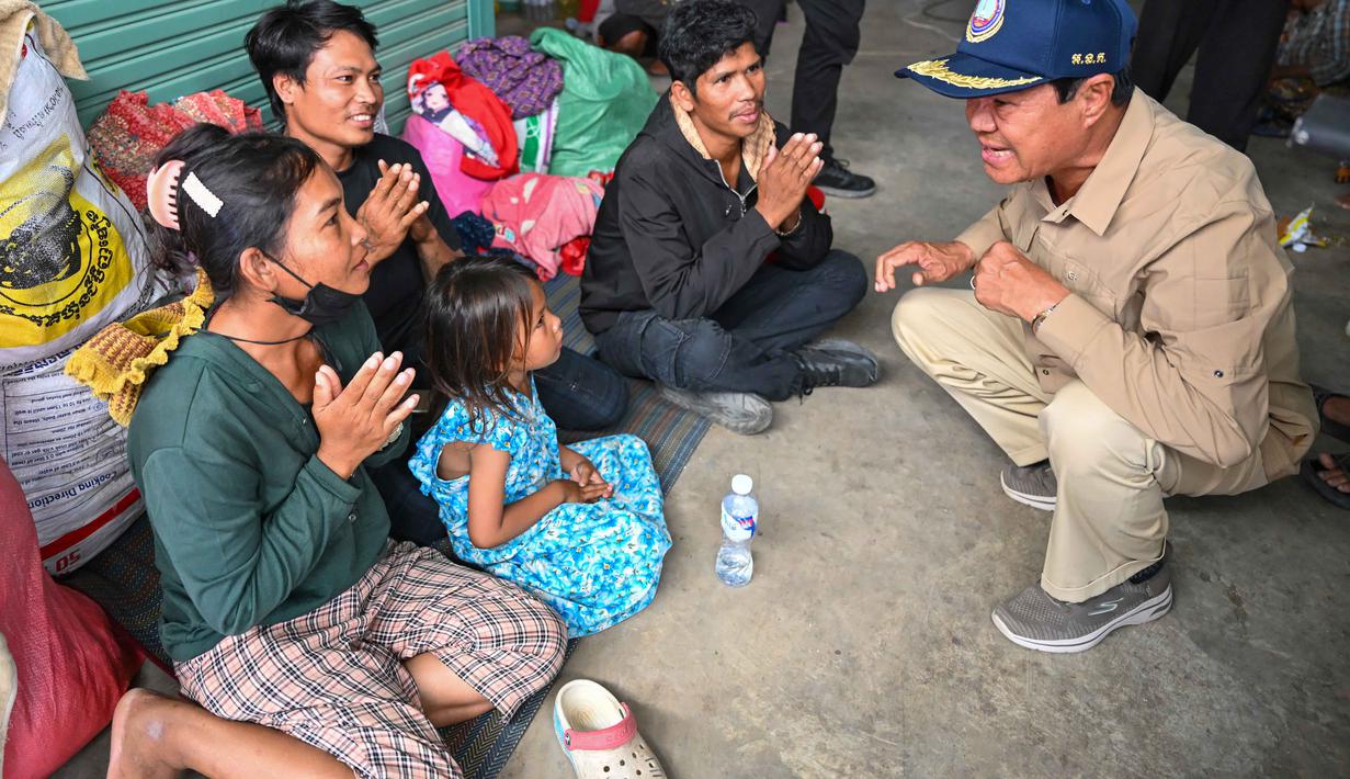 Thailand mencatat lebih dari 400 ribu warga telah dievakuasi ke lokasi yang lebih aman. Sementara, Kamboja melaporkan sedikitnya 192 ribu orang harus mengungsi dari wilayah perbatasan. Tampak dalam foto, Kun Kim (kanan), menteri senior Kamboja untuk misi khusus dan wakil presiden pertama Komite Nasional untuk Manajemen Bencana (NCDM), berbicara kepada warga pengungsi di kamp sementara di provinsi Banteay Meanchey pada Sabtu 13 Desember 2025, di tengah bentrokan di sepanjang perbatasan Kamboja-Thailand. (TANG CHHIN SOTHY/AFP)