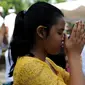 Umat Hindu berdoa saat perayaan Kuningan di sebuah pura di Pulau Serangan, Denpasar, Bali, Sabtu (20/2). Kuningan merupakan hari terakhir perayaan Galungan diyakini menjadi hari kekuasaan roh suci leluhur kembali ke langit. (AFP PHOTO/SONNY Tumbelaka)