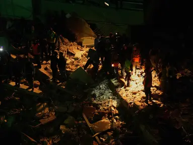 Petugas penyelamat mencari korban selamat di antara reruntuhan bangunan yang rusak setelah serangan udara Israel di Dahiyeh, pinggiran selatan Beirut, Lebanon, Rabu 6 Mei 2026. Serangan udara Israel kembali mengguncang Lebanon. (AP Photo/Hassan Ammar)