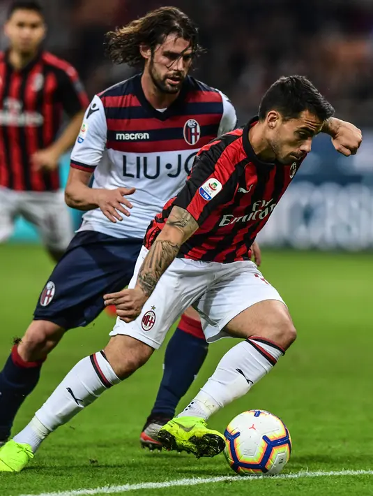 Pemain depan AC Milan, Suso berebut bola dengan pemain Bologna, Andrea Poli dalam laga pekan ke-35 Liga Italia di San Siro, Senin (6/5/2019). AC Milan berhasil mengatasi Bologna 2-1 demi memelihara asa mereka mengamankan tiket ke Liga Champions musim depan. (Miguel MEDINA/AFP)