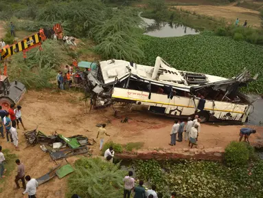 Sebuah derek menarik bus tingkat yang rusak setelah mengalami kecelakaan di jalan bebas hambatan di Agra, India, Senin (8/7/2019). Sebanyak 29 orang dilaporkan tewas dan 18 lainnya terluka dalam kecelakaan bus tersebut. (AP Photo/Pawan Sharma)