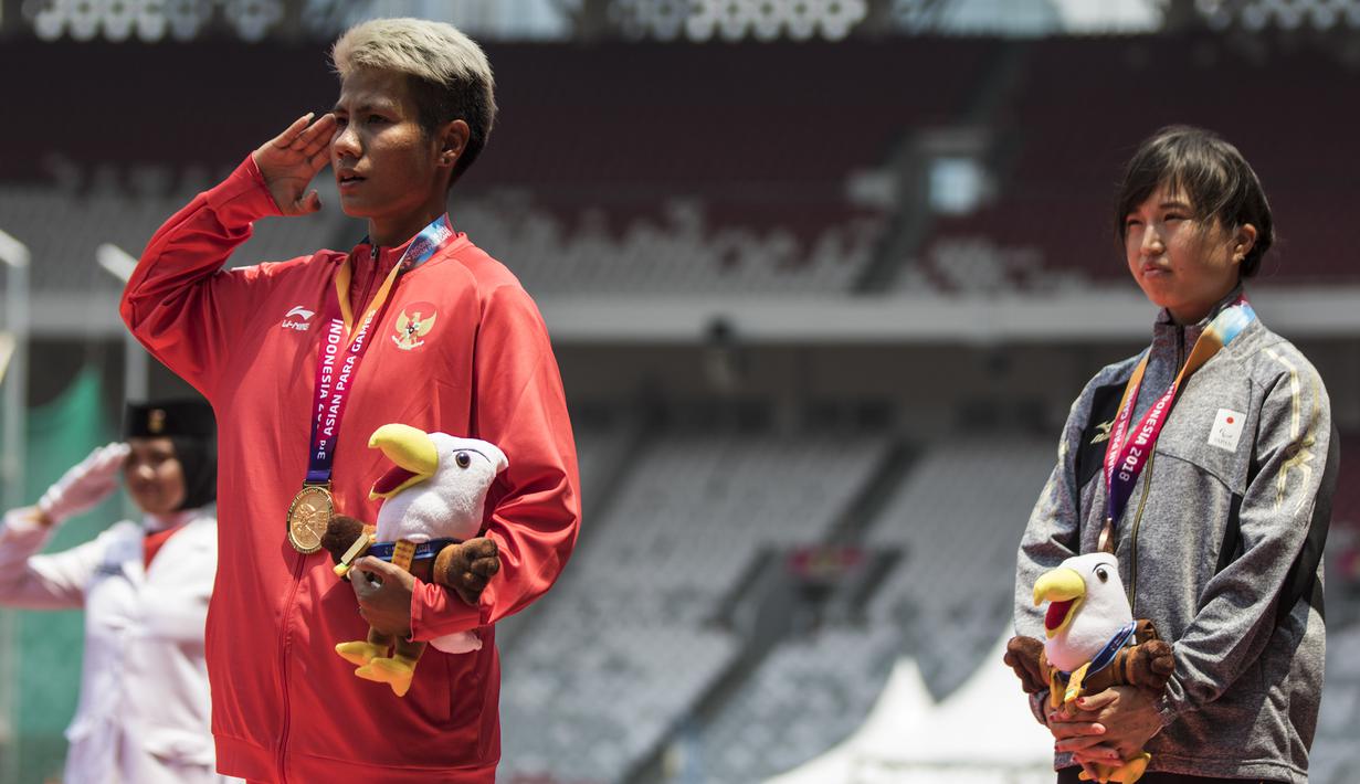 Atlet lompat jauh Indonesia, Rica Oktavia, hormat bendera saat seremoni usai meraih medali emas Asian Para Games 2018 di SUGBK, Jakarta, Senin (8/10/2018). (Bola.com/Vitalis Yogi Trisna)