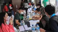 Petugas melakukan pendataan saat program vaksinasi COVID-19 kepada para atlet di Istora Senayan, Jakarta, Jumat (26/2/2021). Sebanyak 5.000 atlet diprioritaskan karena mereka dijadwalkan mengikuti beberapa kejuaraan single event maupun multievent dalam waktu dekat. (Liputan6.com/Faizal Fanani)