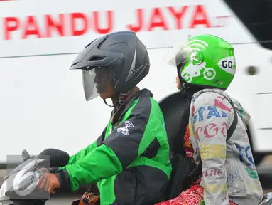 Pengendara ojek online bersama penumpang melintas di kawasan Terminal Kalideres, Jakarta, Selasa (22/3). Dengan adanya aksi demo angkutan umum di ruas Jakarta penumpang terlantar di sejumlah terminal. (Liputan6.com/Faisal R Syam)