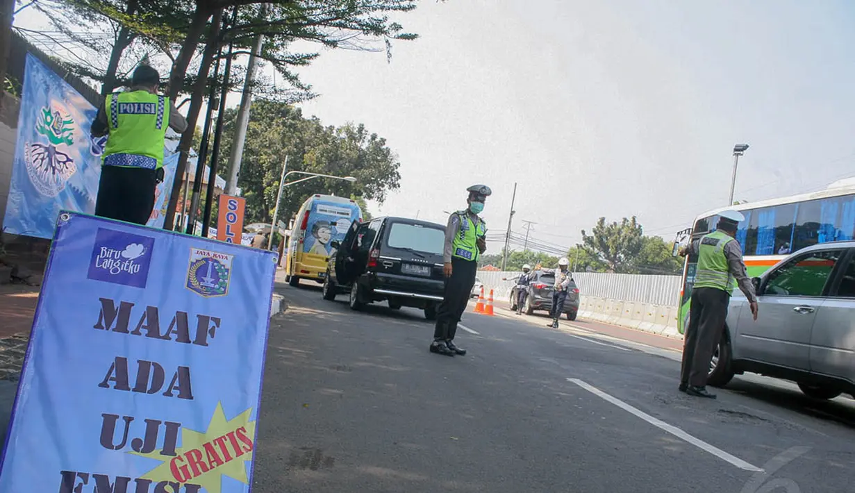 Sejumlah petugas mengarahkan kendaraan yang tengah melintas untuk terlebih dahulu melakukan uji emisi, Jakarta, (23/9/14).  (Liputan6.com/Faizal Fanani) 