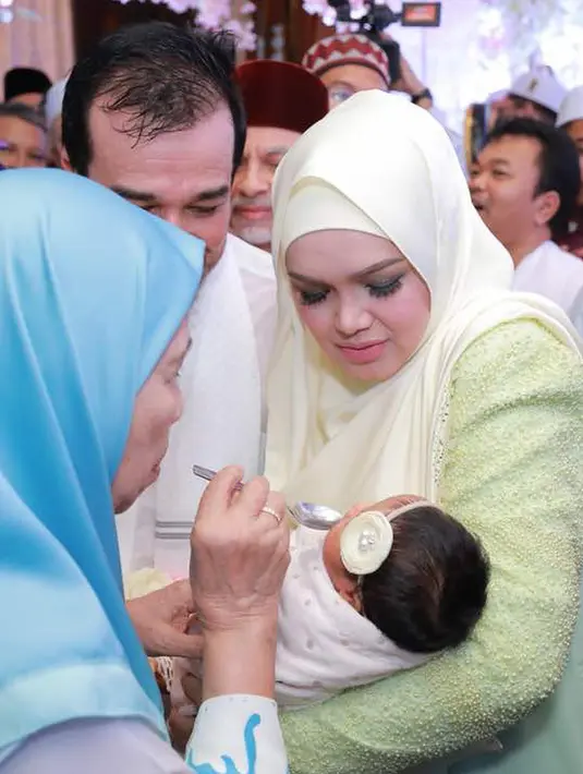 Penyanyi Siti Nurhaliza menggendong anak pertamanya Siti Aafiyah saat acara prosesi akikah. Acara akikah anak Siti Nurhalizah ini pun disiarkan secara langsung melalui akun Youtube miliknya, Siti Official Video. (instagram.com/ctdk)