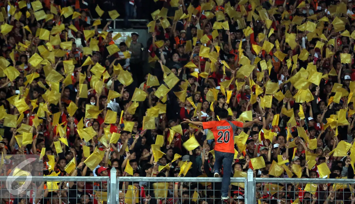 Suporter mengibarkan bendera duka jelang menyaksikan laga Persija melawan PS TNI di Stadion GBK Jakarta, Jumat (10/6). Ungkapan duka ditujukan atas tewasnya M Fahreza saat akan menyaksikanlaga Persija (13/5) lalu. (Liputan6.com/Helmi Fithriansyah)