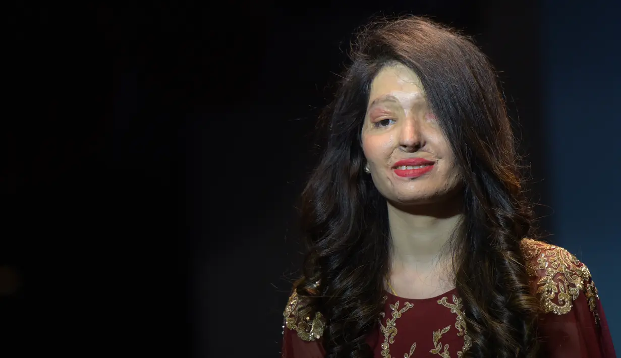Seorang wanita bernama Reshma Qureshi berjalan diatas panggung saat peragaan busana di New Delhi, India (25/11). Pada peragaan ini model yang ditampilkan adalah wanita korban kekerasan dan penyiraman air keras. (AFP Photo/Dominique Faget)