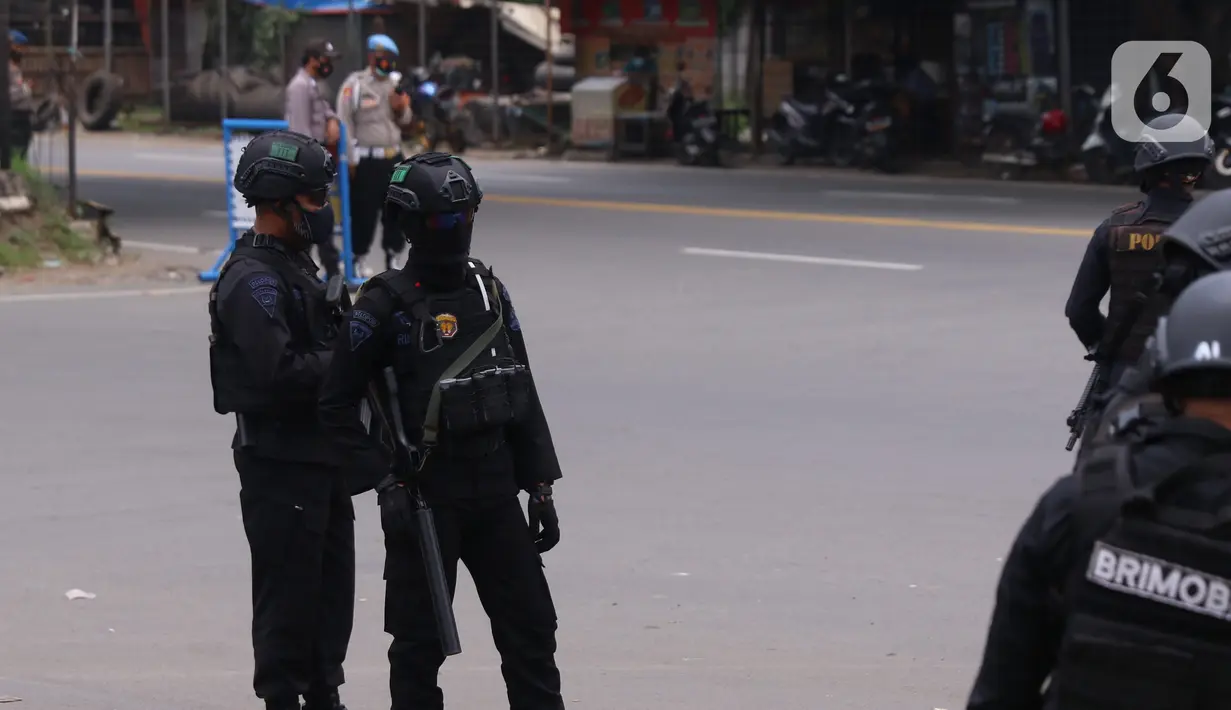 Personel Brimob bersenjata melakukan penjagaan ketat di depan pintu masuk Tol Bitung, Tangerang, Baten, Selasa (6/10/2020). Penjagan ketat dilakukan untuk mengamankan dan mencegah aksi buruh yang akan menggelar aksi menolak UU Cipta Kerja. (Liputan6.com/Angga Yuniar)