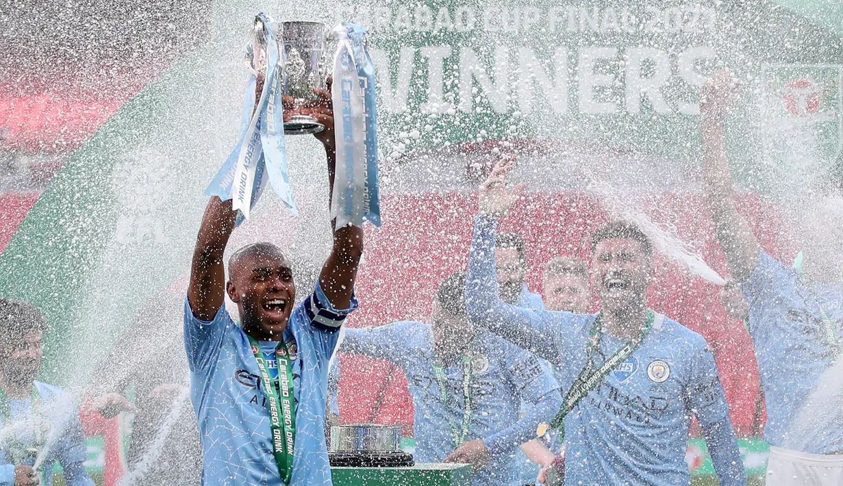 Kapten Manchester City, Fernandinho mengangkat trofi Carabao Cup 2020/21 usai menundukkan Tottenham Hotspur dengan skor tipis 1-0 dalam duel pemungkas di Wembley Stadium. (Foto: AFP/Pool/Carl Recine)