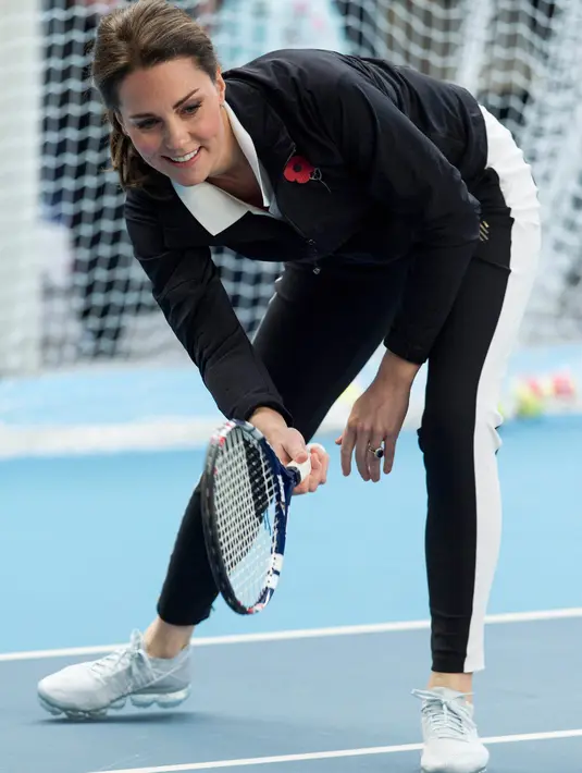 Kate Middleton ambil bagian berlatih tenis dalam kunjungannya ke Lawn Tennis Association di Pusat Tenis Nasional, London, Senin (31/10). Kate yang tengah hamil anak ketiga itu tampak mengenakan pakaian serba sporty. (Daniel Leal Olivas/Pool via AP)