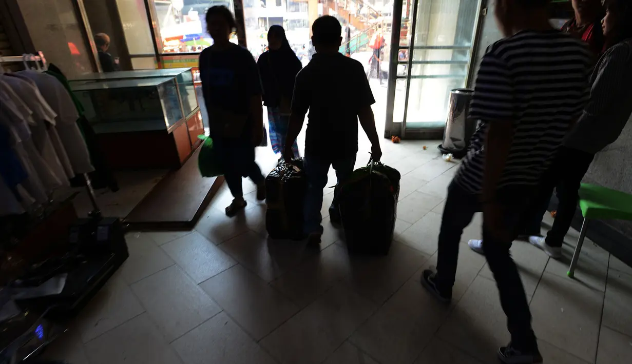 Seorang pria membawa belanjaannya di Pasar Tanah Abang, Jakarta, Sabtu (25/5/2019). Pasca Aksi 22 Mei 2019, para pedagang mengalami kerugian karena perputaran uang di Tanah Abang mencapai Rp 200 miliar per hari. (merdeka.com/Imam Buhori)