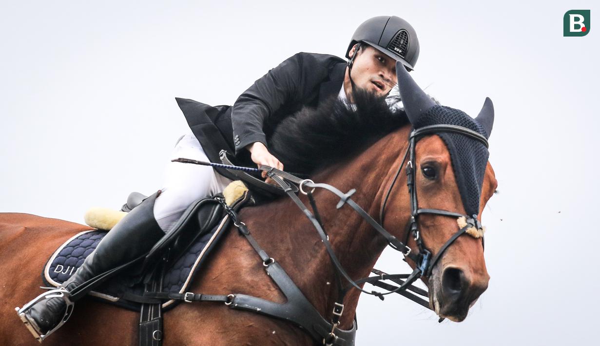 Atlet berkuda tim Djiugo, Reshwara Radinal beraksi pada nomor Show Jumping 110 cm saat ajang Solidarity Equestrian Challange 2022 yang berlangsung di Jakarta International Equestrian Park, Jakarta Timur, Minggu (30/01/2022). (Bola.com/Bagaskara Lazuardi)