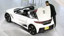 Pria melihat mobil Honda S660 di markas besar Honda Motor Co di Tokyo, Jepang, (24/2). Setelah hampir setahun pengerjaan, CEO Honda Motor Co Takahiro Hachigo berencana memperkenalkan mobil Honda S660 ke Publik. (REUTERS/Thomas Peter)