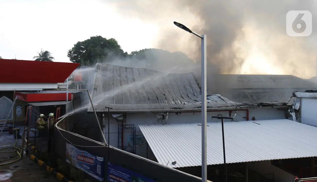 Petugas memadamkan api saat terjadi kebakaran di Gudang JNE Express, Jalan Pekapuran Raya, Depok, pada Senin (12/9/2022). Kepala Bidang Pengendalian Operasional Dinas Pemadam Kebakaran dan Penyelamatan Kota Depok Welman Naipospos mengatakan, kebakaran di gudang JNE Depok ini diduga terjadi akibat korsleting atau hubungan pendek arus listrik. (Liputan6.com/Herman Zakharia)