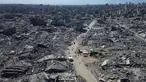 Foto udara yang diambil menggunakan pesawat tanpa awak atau drone memperlihatkan beberapa warga Palestina berjalan di sepanjang jalan yang dikelilingi oleh bangunan-bangunan yang hancur akibat serangan militer Israel selama dua tahun terakhir di Kota Gaza, Rabu 15 Oktober 2025. (AP Photo)