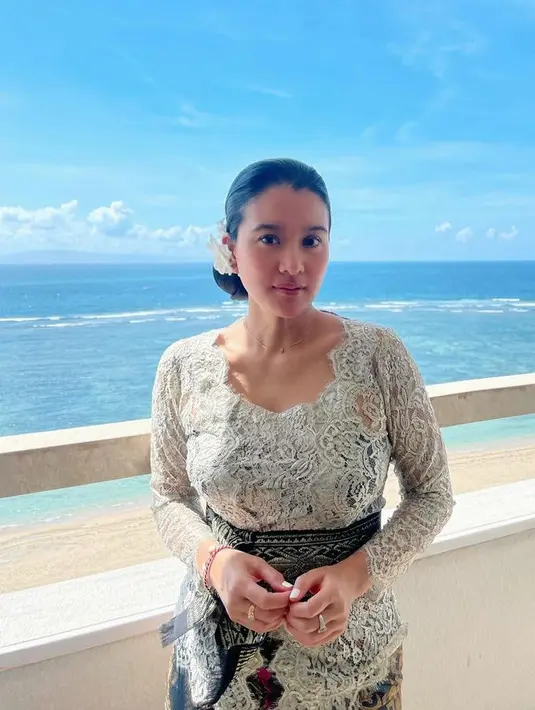 Marcella memilih mengenakan tampil bak perempuan Bali dengan kebaya brokat lengan panjang warna putih dipadukan obi hitam motif keemasan.  [@marcella.zalianty]