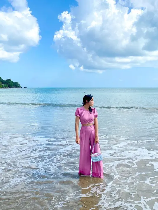 Masih di pantai, kali ini Tiffany tampil dengan outfit lebih tertutup. Ia mengenakan setelan atasan crop top dan celana panjang berwarna ungu yang senada. Foto: Instagram.