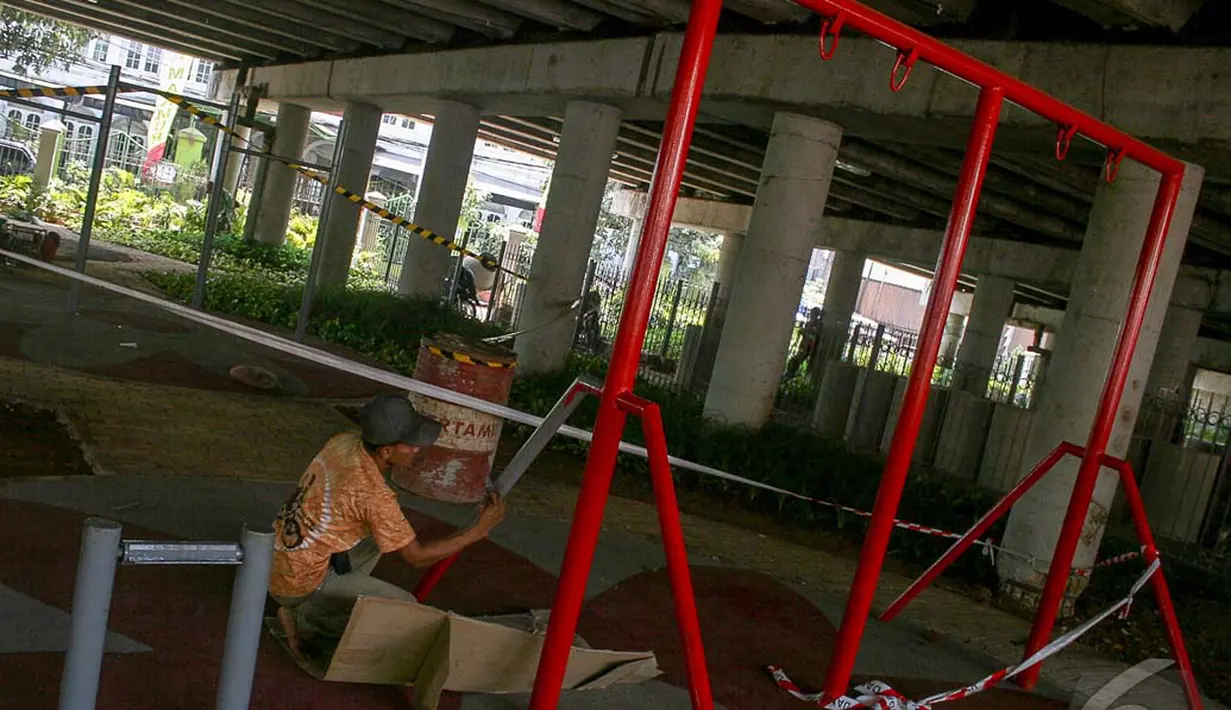 Seorang pekerja sedang mengecat ayunan yang berada di Taman Aktif of Klender, Jakarta, Senin (22/9/2014) (Liputan6.com/Faizal Fanani)