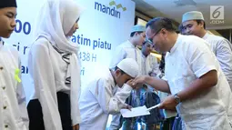 Seorang anak menyalami Dirut Bank Mandiri Kartika Wirjoatmodjo saat acara buka puasa di Jakarta, Minggu (11/6).  Dalam kegiatan ini Bank Mandiri Group memberikan bingkisan Ramadan kepada 21.000 anak yatim piatu. (Liputan6.com/Angga Yuniar)