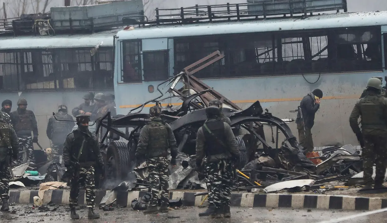 Tentara India memeriksa puing-puing setelah ledakan bom mobil di Lethpora di distrik Pulwama, Kashmir, India (14/2). Sedikitnya 16 tentara India tewas dan 20 orang terluka akibat kejadian tersebut. (AFP Photo/STR)