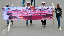Massa dari Pergerakan Pelaut Indonesia (PPI) membentangkan spanduk ketika berunjuk rasa di Jalan Merdeka Barat, Jakarta, Kamis (12/5). Massa menuntut pemerintah memperhatikan kesejahteraan dan peningkatan upah mereka. (Liputan6.com/Yoppy Renato)