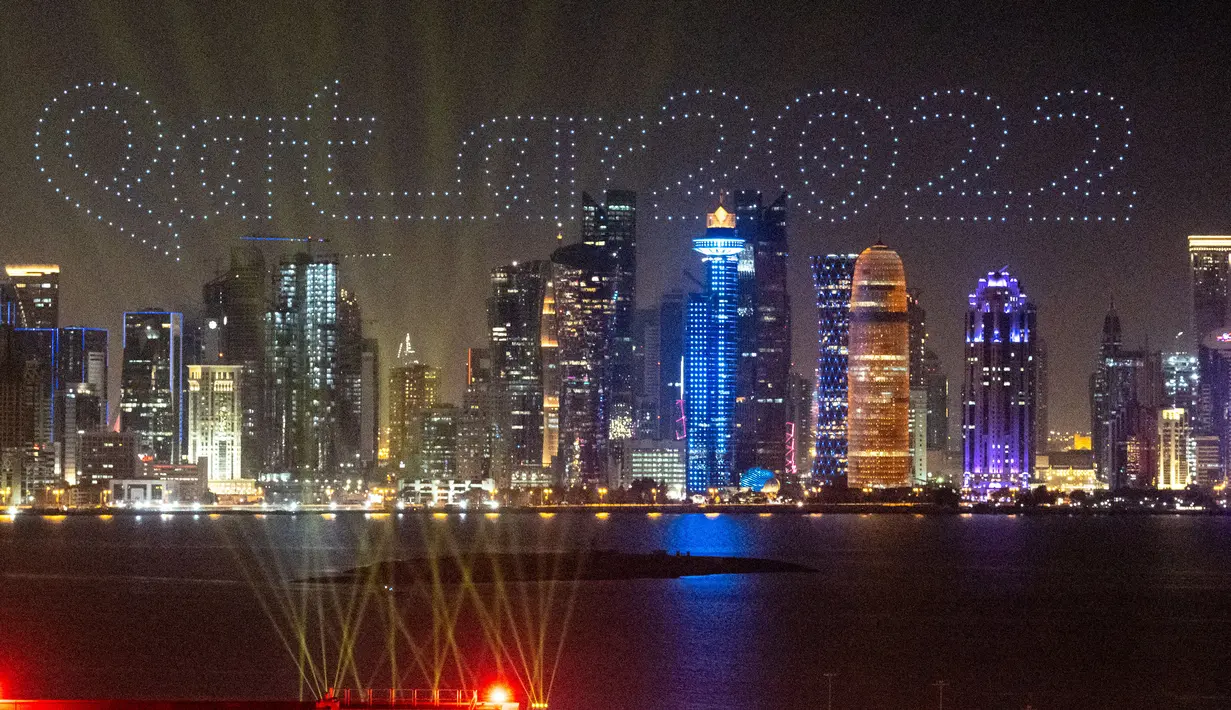 Drone bermanuver membentuk tulisan “Qatar 2022” di atas ibu kota Qatar, Doha, pada Minggu (21/11/2021). Qatar akan menyelenggarakan Piala Dunia pertama di Timur Tengah setahun dari sekarang, di delapan stadion di dalam dan sekitar ibu kota Doha. (AMMAR ABD RABBO / Qatar Museums)