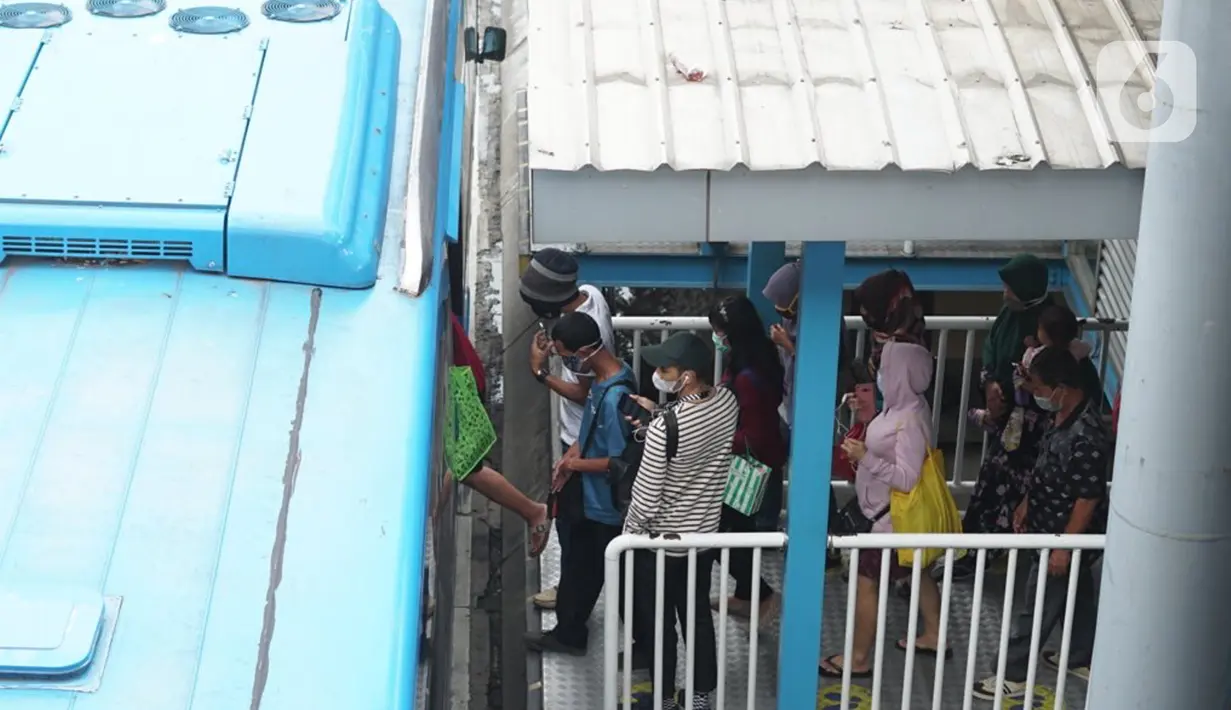 Penumpang menunggu kedatangan bus Transjakarta di Shelter Harmoni, Jakarta, Kamis (5/11/2020). PT Transportasi Jakarta (Transjakarta) menargetkan di tahun 2030 seluruh armada merupakan bus listrik. Diharapkan total bus listrik mencapai 12.120 unit diakhir tahun 2030. (Liputan6.com/Immanuel Antonius)