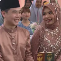 Setelah akad nikah, kedua pasangan ini memamerkan buku nikah. Terlihat sang pengantin perempuan mengenakan baju senada berpayet lengkap dengan kerudungnya. [Instagram/@kimgunwoooooo]