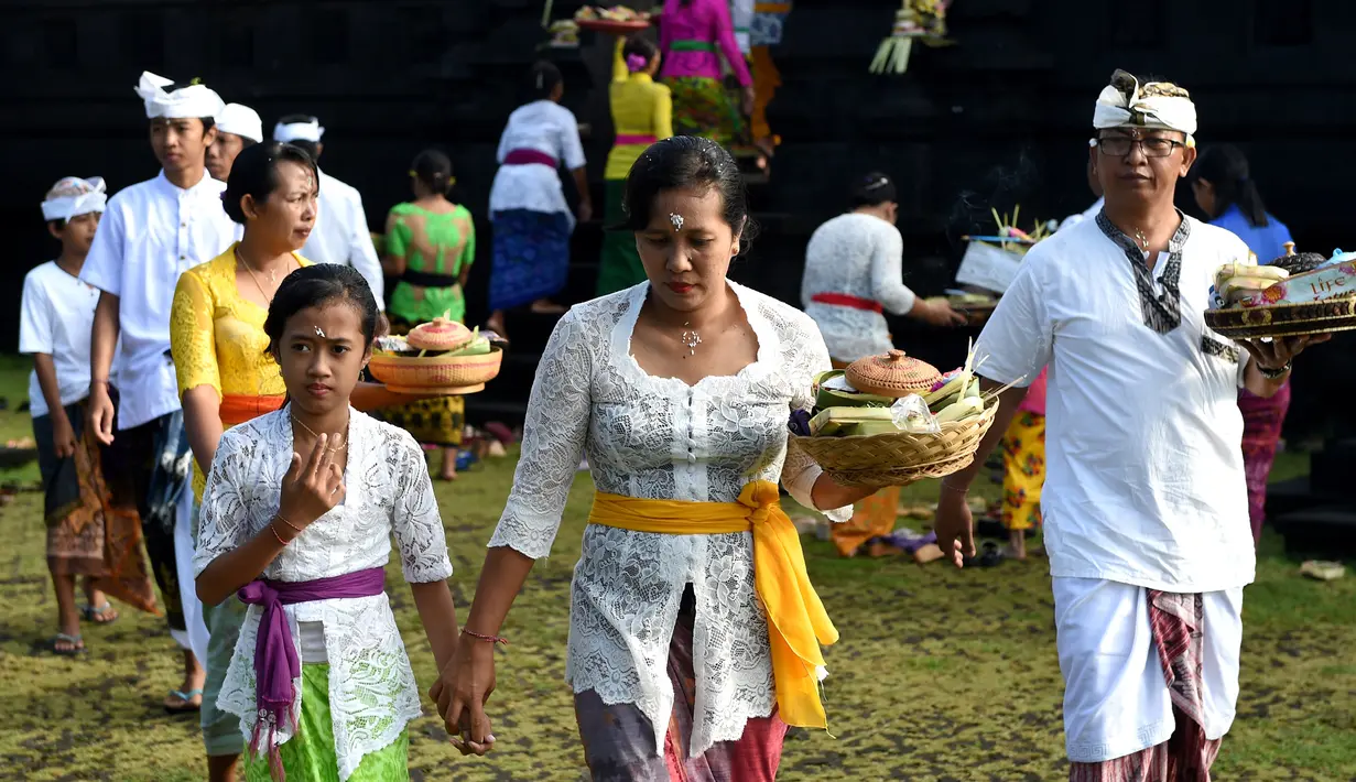 Umat Hindu membawa sesajen menuju pura untuk sembahyang Hari Raya Galungan di Jimbaran, Bali, Rabu (5/4). Galungan dirayakan oleh umat hindu di Bali sebagai hari kemenangan Dharma (Kebaikan) melawan Adharma (Keburukan). (SONNY TUMBELAKA/AFP)