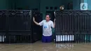 Warga melihat situasi dari pagar rumah saat banjir di RW 07, Kelurahan Pekayon, Jakarta Timur, Sabtu (20/2/2021). Banjir di kawasan tersebut terjadi akibat curah hujan yang tinggi. (Liputan6.com/Herman Zakharia)