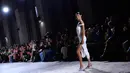 Model AS Bella Hadid menampilkan kreasi saat peragaan busana Coperni Spring-Summer 2023 pada Paris Fashion Week di Paris, Prancis, 30 September 2022. Gaun yang dikenakannya dapat dilepas dan diubah kembali menjadi larutan cair untuk digunakan ulang. (JULIEN DE ROSA/AFP)
