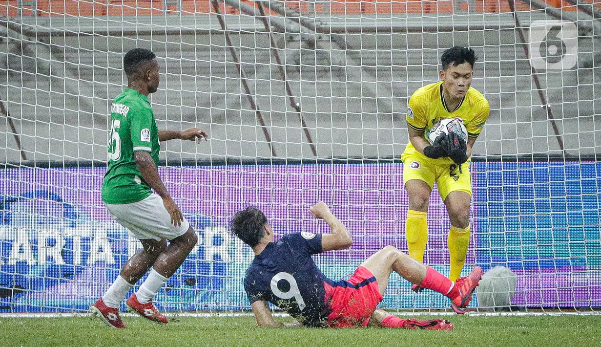 Kiper Indonesia All Stars U-20 menangkap bola yang ditendang pemain Atletico Madrid U-18 Pablo Pozos pada laga ketiga International Youth Championship (IYC) 2021  di Jakarta International Stadium (JIS), Minggu (17/4/2022) malam. Atletico Madrid U-18 menang tipis 2-1. (Liputan6.com/Faizal Fanani)