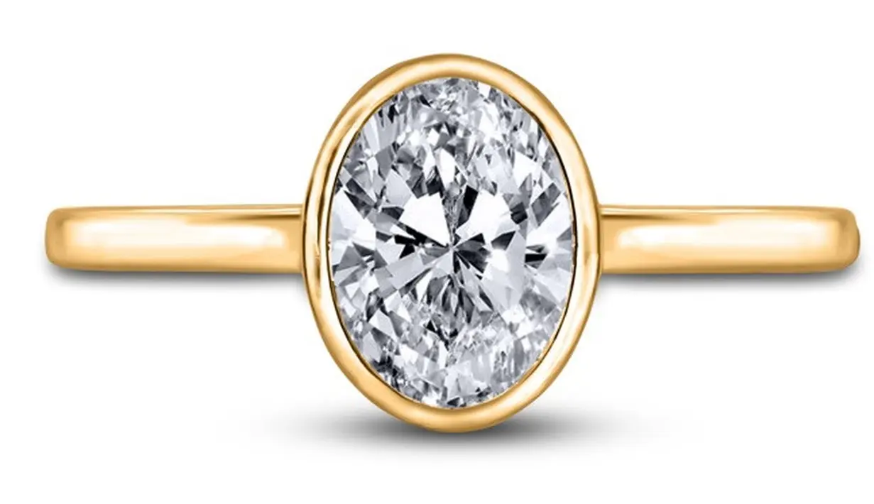 Cincin set bezel. Jika kamu menyukai gaya klasik atau minimalis, mungkin kamu juga akan menyukai cincin set bezel. Pengaturan bezel adalah ketika berlian dikelilingi oleh cincin logam mulia untuk menahannya, menciptakan tepian yang benar-benar halus. Pengaturan ini bisa ditambahkan ke berbagai potongan berlian, tapi paling populer dipasangkan dengan berlian bulat atau oval. Foto: StyleCaster.