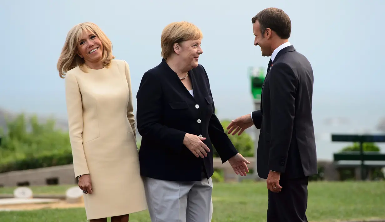 Presiden Prancis Emmanuel Macron (kanan) dan istrinya Brigitte Macron (kiri) menyambut Kanselir Jerman Angela Merkel (tengah) yang tiba di KTT G7, Biarritz, Prancis, Sabtu (24/8/2019). KTT G7 ini berlangsung selama tiga hari di resor tepi laut Atlantis. (Sean Kilpatrick/The Canadian Press via AP)