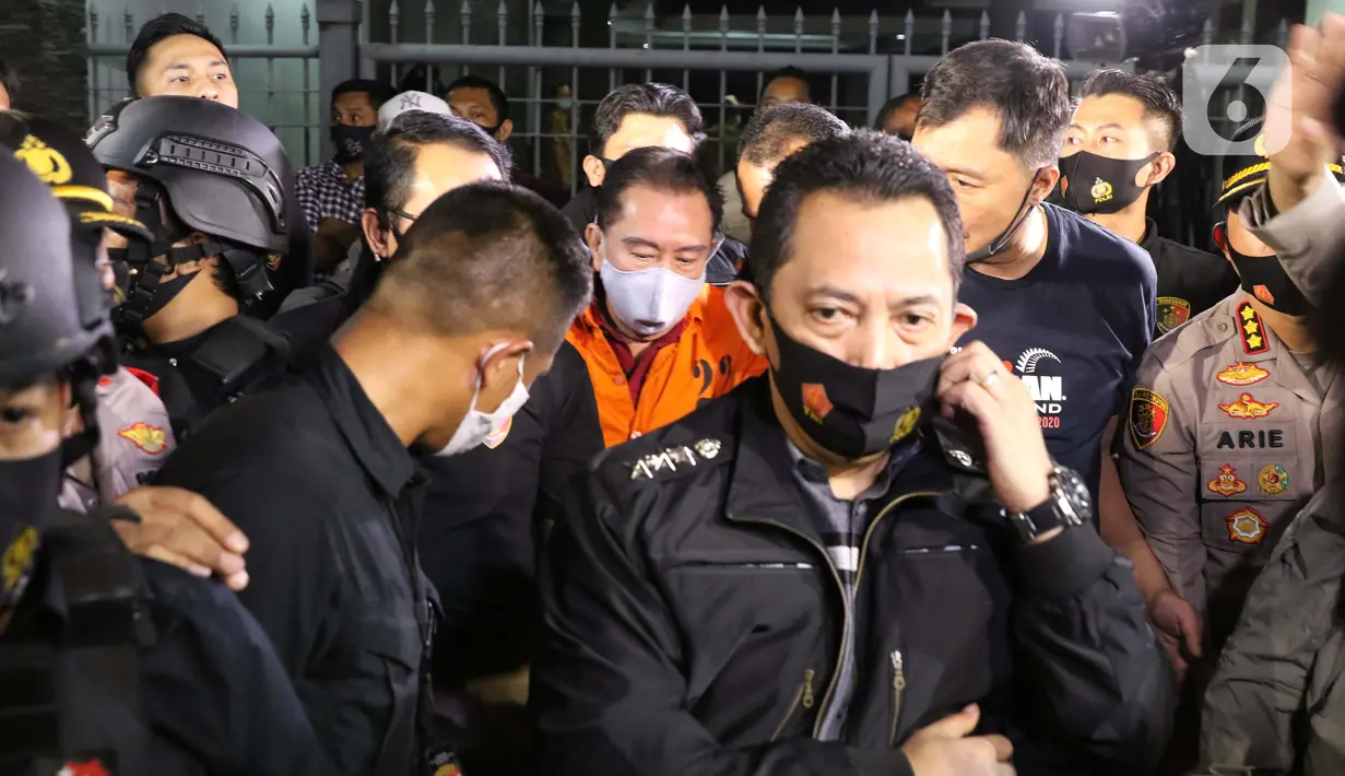 Terpidana pengalihan hak tagih atau cessie Bank Bali, Djoko Sugiarto Tjandra (rompi oranye) dikawal petugas usai tiba di Bandara Halim Perdanakusuma Jakarta, Kamis (30/7/2020). Djoko Tjandra tiba sekitar pukul 22.30 WIB dan langsung dibawa ke Bareskrim Mabes Polri. (Liputan6.com/Helmi Fithriansyah)