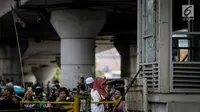 Warga berkerumun di Halte TransJakarta Kampung Melayu, yang tidak beroperasi karena terdampak ledakan bom, Kamis (25/5). Warga terus berdatangan untuk melihat langsung lokasi ledakan bom yang menewaskan tiga polisi tersebut. (Liputan6.com/Faizal Fanani)