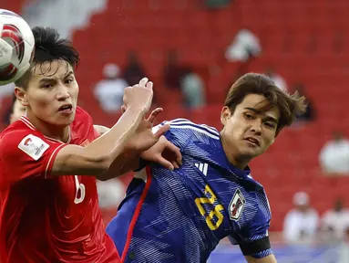 Pemain Vietnam, Nguyen Thanh Binh (kiri) berebut bola dengan pemain Jepang, Kaishu Sano pada laga Grup D Piala Asia 2023 di Al Thumama Stadium, Qatar, Minggu (14/01/2024). (AFP/Karim Jaafar)