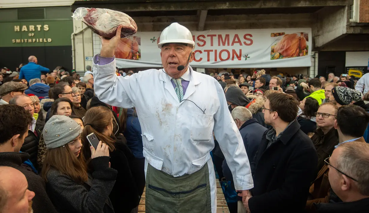 Penjual melelang potongan daging selama lelang tahunan di Smithfield Market, kota London, 24 Desember 2018. Dalam tradisi Natal sejak zaman Victoria ini calon pembeli mendapatkan diskon besar-besaran berbagai daging sapi dan domba. (NIKLAS HALLE'N/AFP)