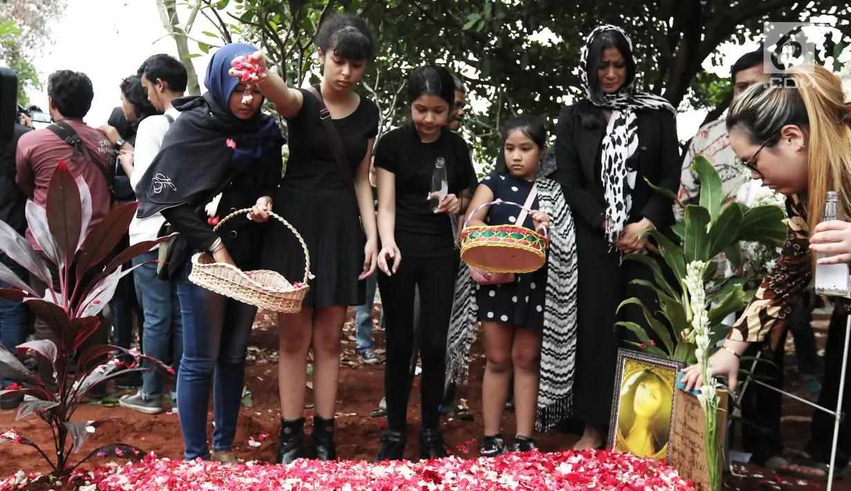 Putri Yana Zein, Aurelia Callista Carilla menaburkan bunga di makam Yana Zein di TPU Gandul, Cinere, Depok, Jumat (2/6). Yana Zein meninggal pada kamis (1/6/2017), karena kanker payudara stadium VI yang dideritanya. (Liputan6.com/Herman Zakharia)