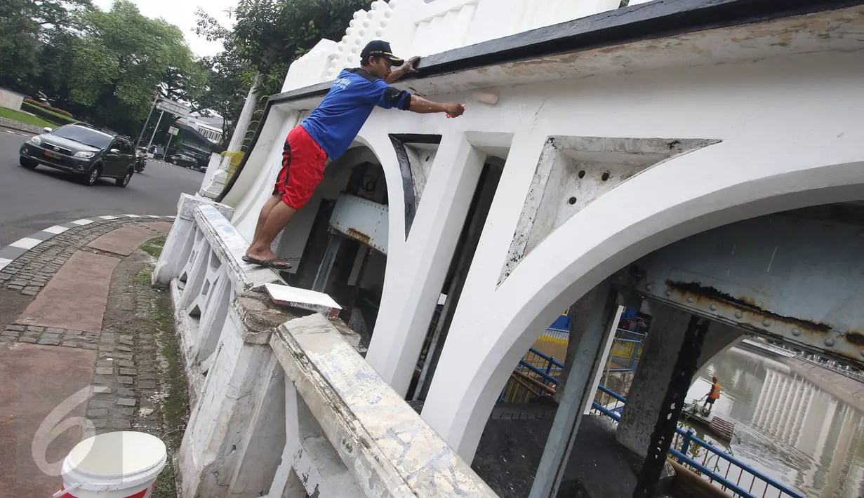 Pekerja melakukan pengecatan pintu air Istiqlal, Jakarta Pusat, Senin (14/11). Pengecatan dilakukan untuk menjaga pintu air yang merupakan salah satu cagar budaya tersebut agar tetap bersih dan terawat. (Liputan6.com/Immanuel Antonius)