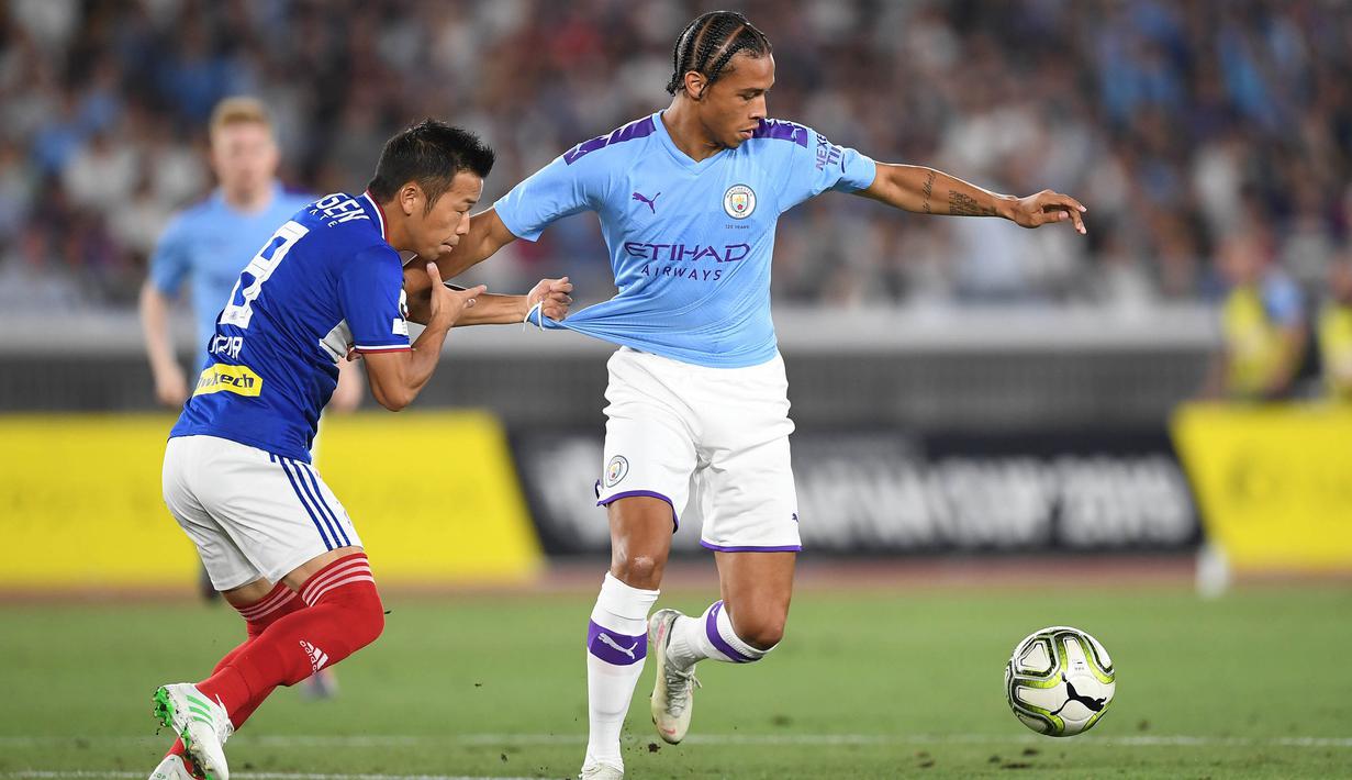 Gelandang Yokohama Marinos, Takuya Kida, berebut bola dengan gelandang Manchester City, Leroy Sane, pada laga pramusim di Stadion Yokohama, Jepang, Sabtu (27/7). Yokohama kalah 1-3 dari City. (AFP/Charly Triballeau)