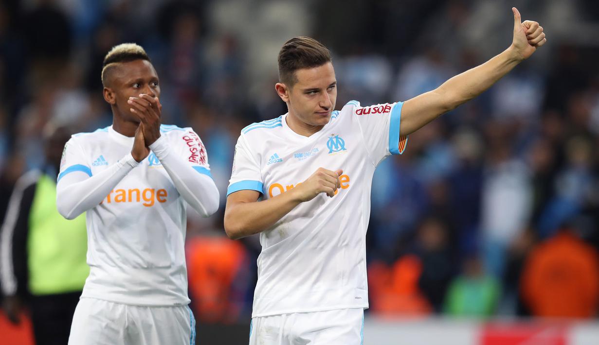 Pemian Marseille, Florian Thauvin (kanan) dan Clinton Njie memberikan salam kepada fans pada lanjutan Ligue 1 di  Velodrome Stadium, Marseille, (22/10/2017). PSG bermain imbang 2-2 melawan Marseille. (AFP/Valery Hache)