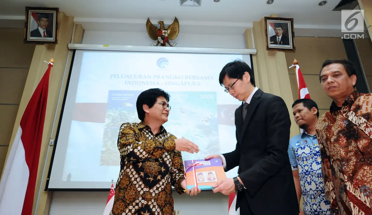 Dirjen Penyelenggaraan Pos dan Informatika, M Ramli (kiri) menyerahkan cenderamata kepada Director of Mission Singapore, Jonathan Han usai penandatanganan dan peluncuran perangko bersama di Jakarta, Kamis (7/9). (Liputan6.com/Helmi Fithriansyah)