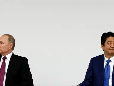 Presiden Rusia Vladimir Putin dan Perdana Menteri Jepang Shinzo Abe menggelar konferensi pers di Tokyo, Jumat (16/12). Pertemuan Putin dan Abe membahas soal wilayah sengketa antara Jepang dan Rusia. (REUTERS/Kim Kyung-Hoon)