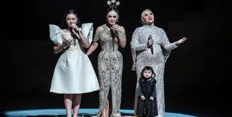 Dalam penampilannya, sosok mungil menggemaskan, yakni Ameena yang turut hadir di panggung yang sama tak luput dari perhatian.  Mereka tampil kompak mengenakan gaun yang glamor nuansa hitam dan emas. [Instagram/aurelie.hermansyah]