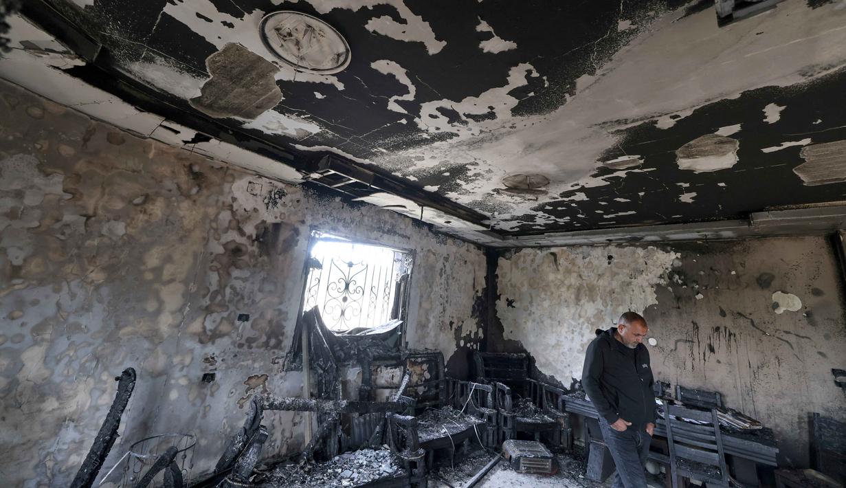 Hingga Maret 2026, serangan pemukim Israel di wilayah Nablus dan sekitarnya terus mengalami peningkatan yang signifikan, terutama selama bulan suci Ramadan. Tampak dalam foto, seorang pria Palestina memeriksa sisa-sisa rumah yang terbakar setelah serangan yang dilaporkan dilakukan oleh pemukim Israel di desa Deir al-Hatab, sebelah timur kota Nablus, di Tepi Barat, wilayah yang diduduki Israel pada Senin 23 Maret 2026. (JAAFAR ASHTIYEH/AFP)