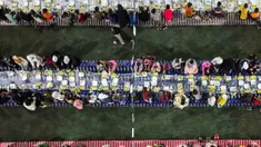 Foto udara ini menunjukkan acara buka puasa bersama yang diselenggarakan oleh sebuah badan amal untuk lebih dari seribu anak, termasuk 800 anak yatim piatu, di sebuah lapangan sepak bola di kota Binnish, provinsi Idlib, Suriah, pada 29 Maret 2024. (Omar HAJ KADOUR/AFP)